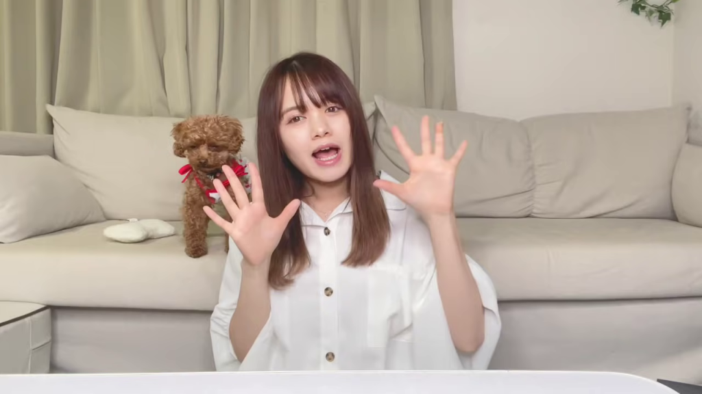 女性が両手を広げ、犬が後ろにいる様子