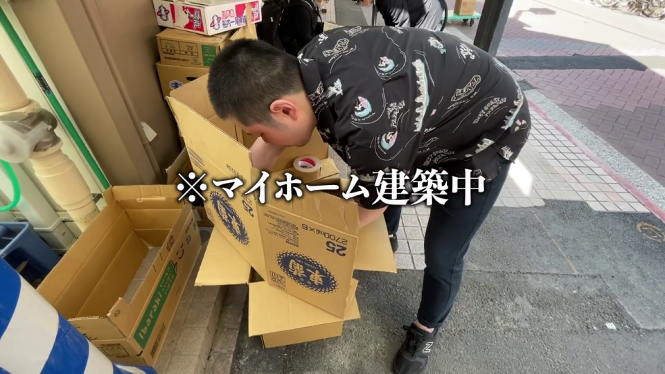 段ボール箱で「マイホーム建築中」の男性