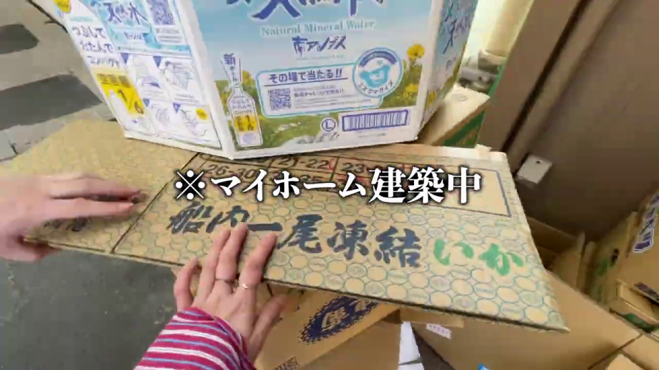 カッターで段ボールを加工する「マイホーム建築中」の男性