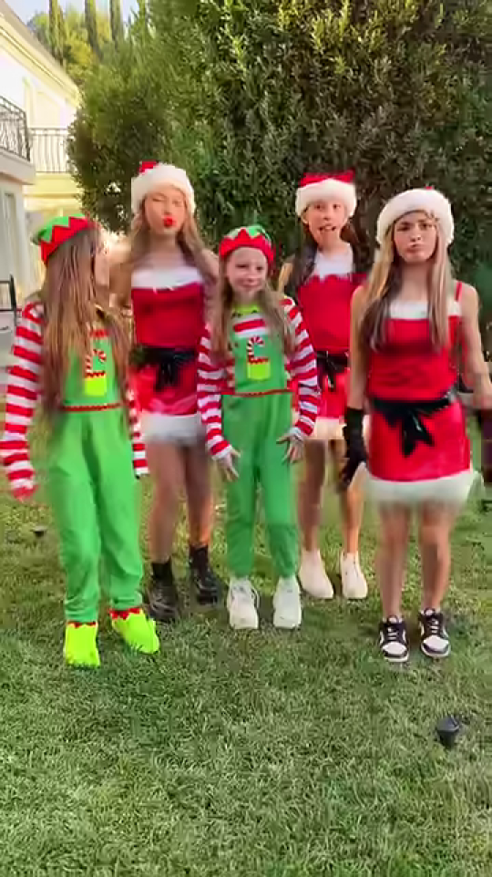 クリスマス衣装の5人の少女が庭に立つ