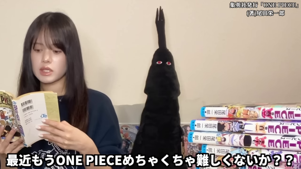 大量のONE PIECE単行本を手に持つ女性