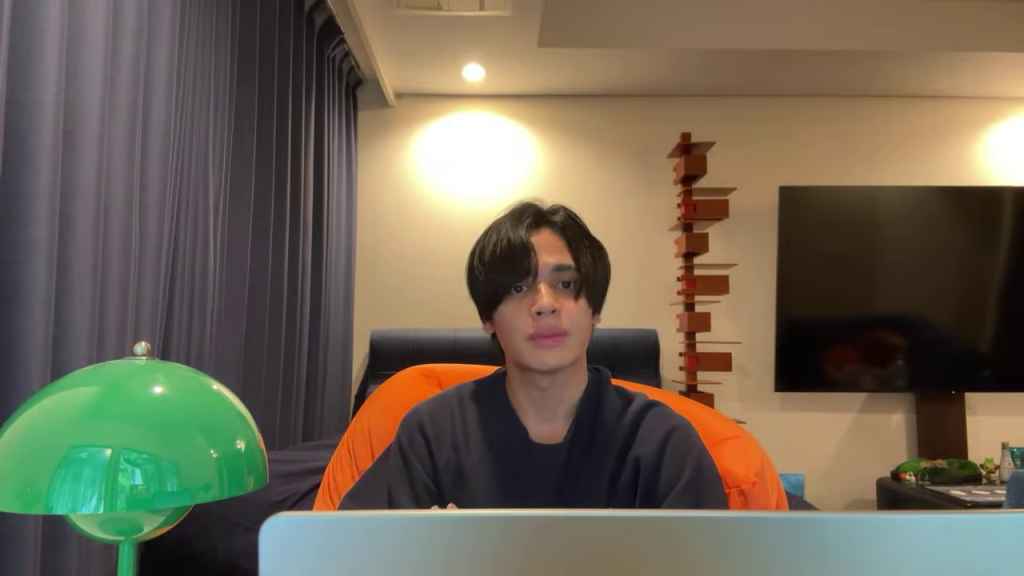 - 手を上げる男性。インペルダウンのロゴとイム様の王冠の類似性について解説している場面。