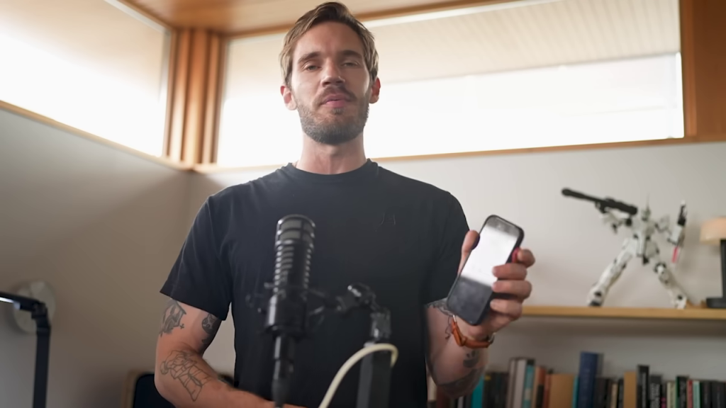 スマートフォンを掲げて説明するPewDiePie