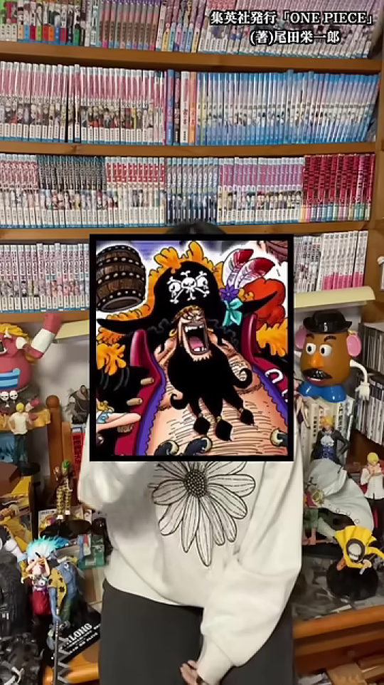 黒ひげのイラストで顔が隠された女性と漫画棚の背景